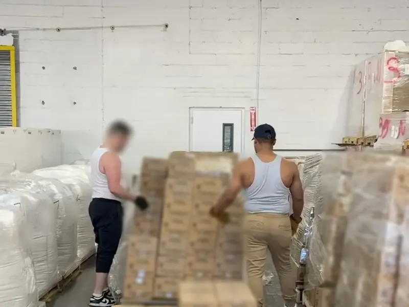 Two workers building a pallet of cartons for an outbound shipment in Carlstadt, NJ